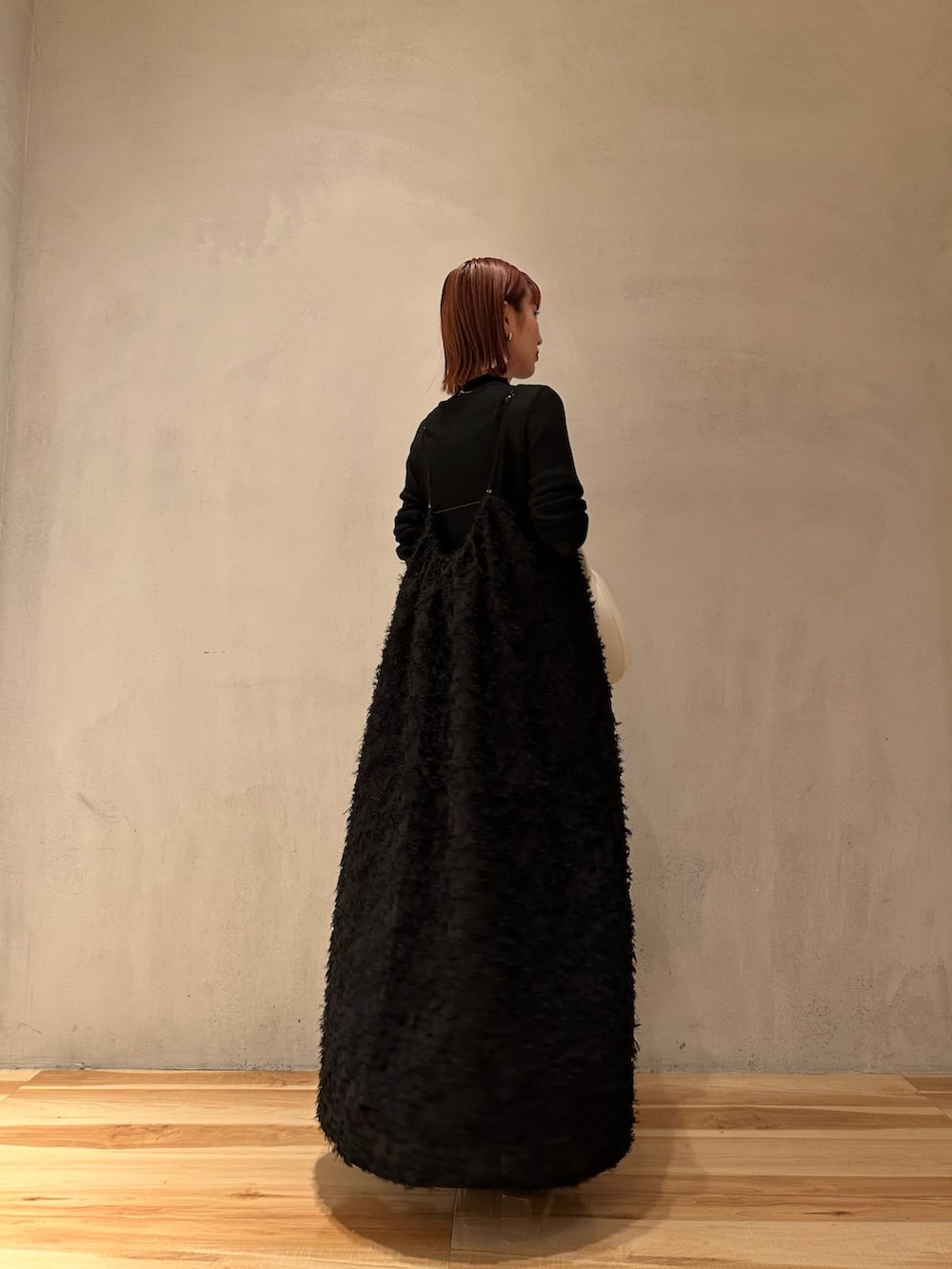 シルバー系のパンプス、ブラック系のワンピースを着用したレディースの秋コーディネートの4枚目の写真