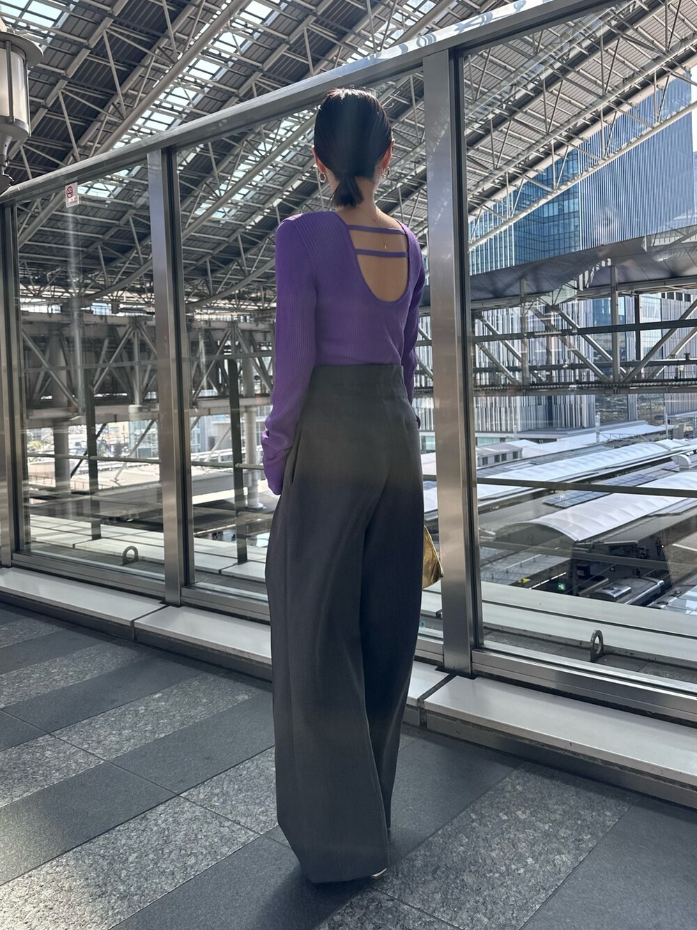 パープル系のニット/セーター、グレー系のその他パンツ、ゴールド系のハンドバッグを着用したレディースの春コーディネートの4枚目の写真