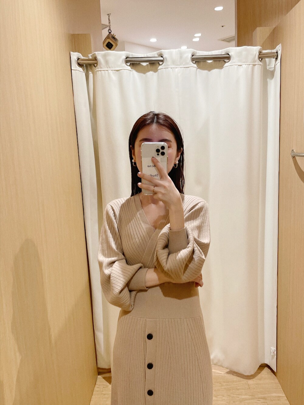 ベージュ系のワンピースを着用したレディースの冬コーディネートの2枚目の写真