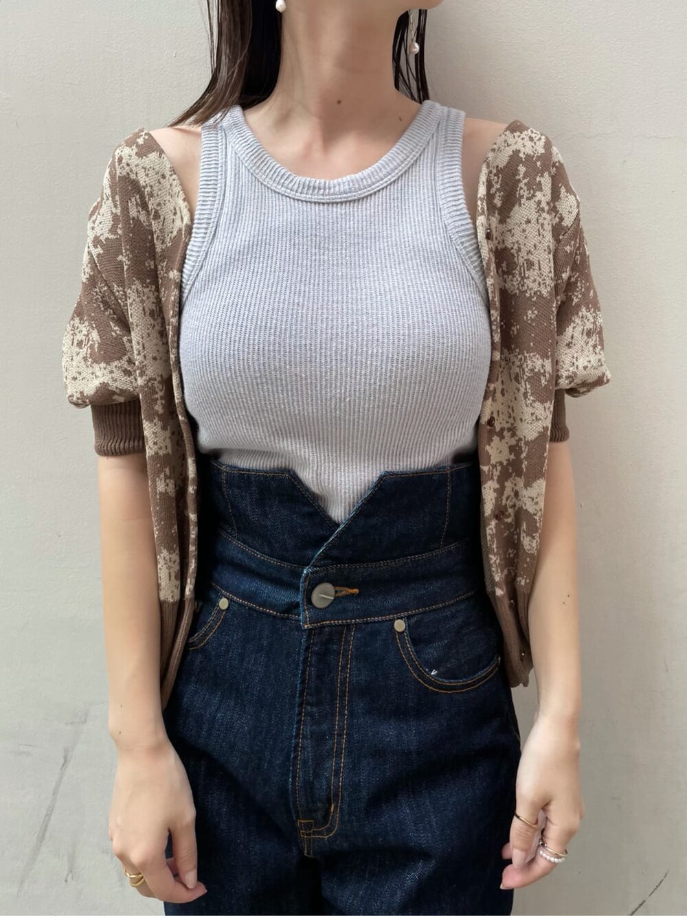 ブルー系のデニムパンツ、オレンジ系のスリッポン、ブラウン系のニット/セーターを着用したレディースの秋コーディネートの2枚目の写真