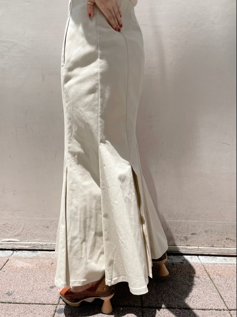 ブラウン系のパンプス、ホワイト系のスカート、ホワイト系のTシャツ/カットソーを着用したレディースの夏コーディネートの6枚目の写真