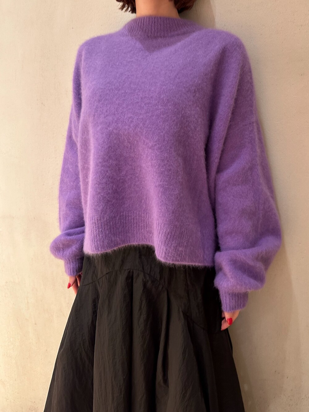 ブラック系のスカート、パープル系のニット/セーター、ブラック系のブーツを着用したレディースの秋コーディネートの7枚目の写真