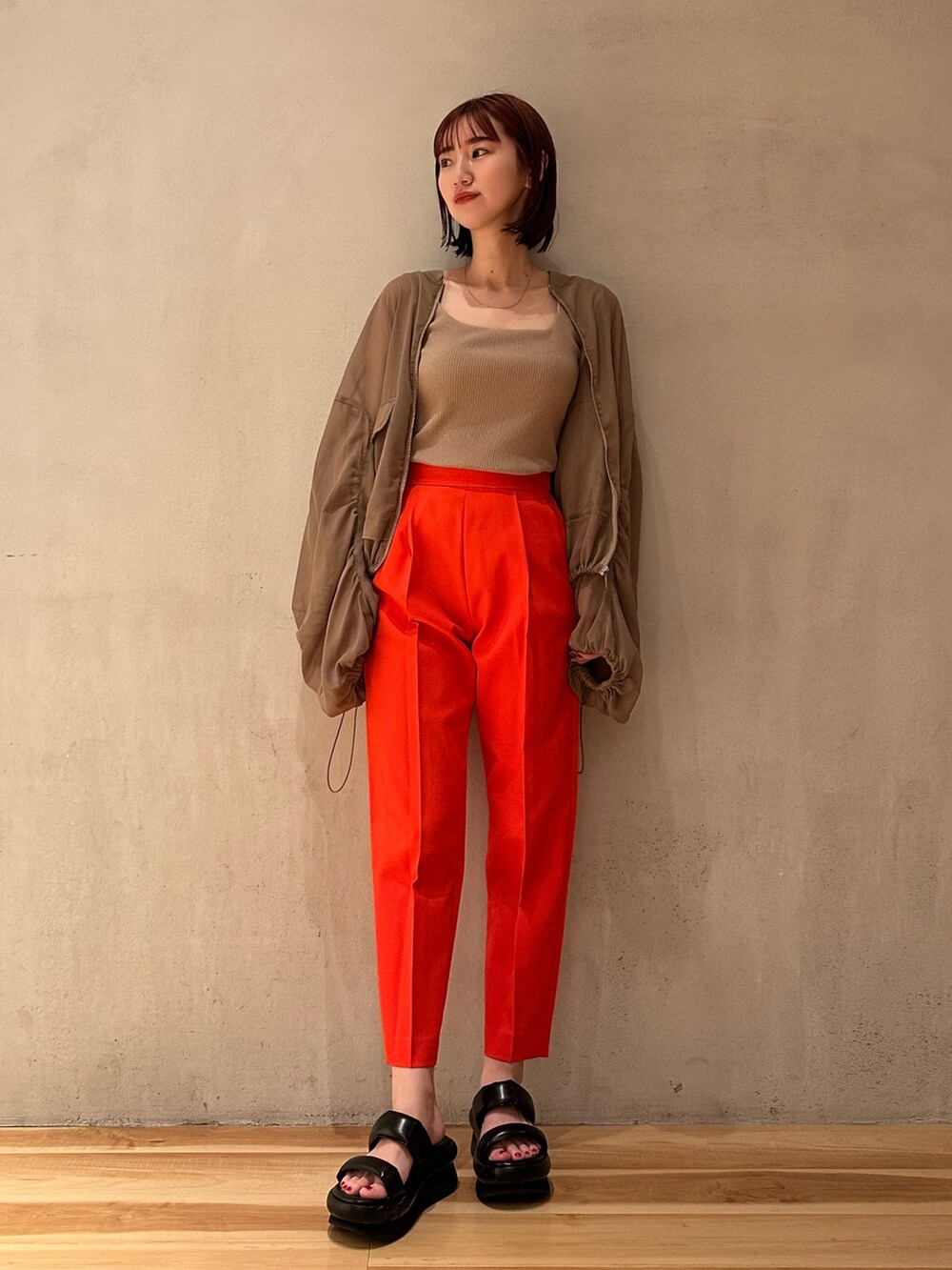 レッド系のその他パンツ、ベージュ系のタンクトップ、ブラウン系のブルゾンを着用したレディースの春コーディネートの2枚目の写真