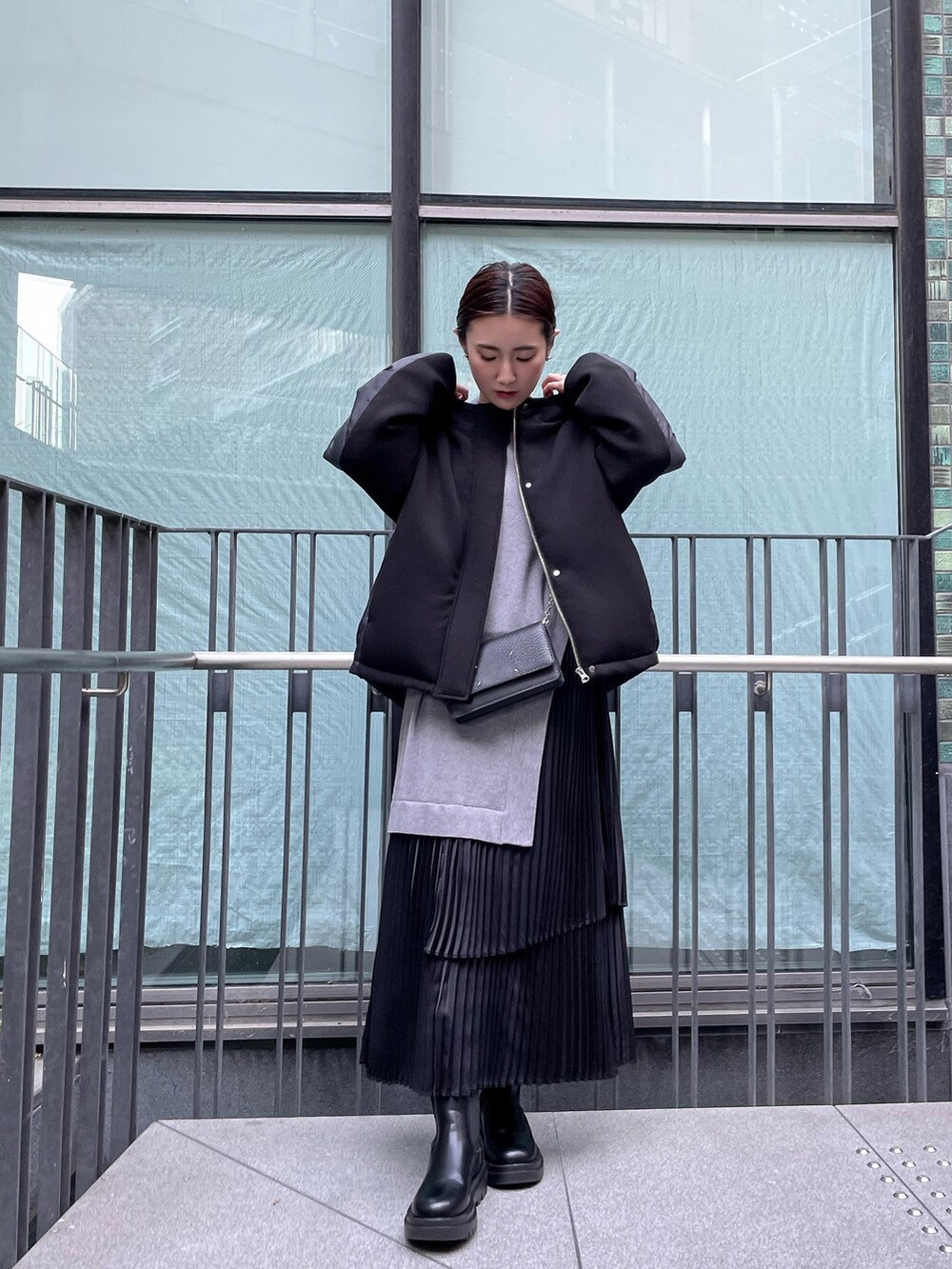 グレー系のワンピース、ブラック系のダウンジャケット/コート、ブラック系の財布を着用したレディースの冬コーディネートの2枚目の写真