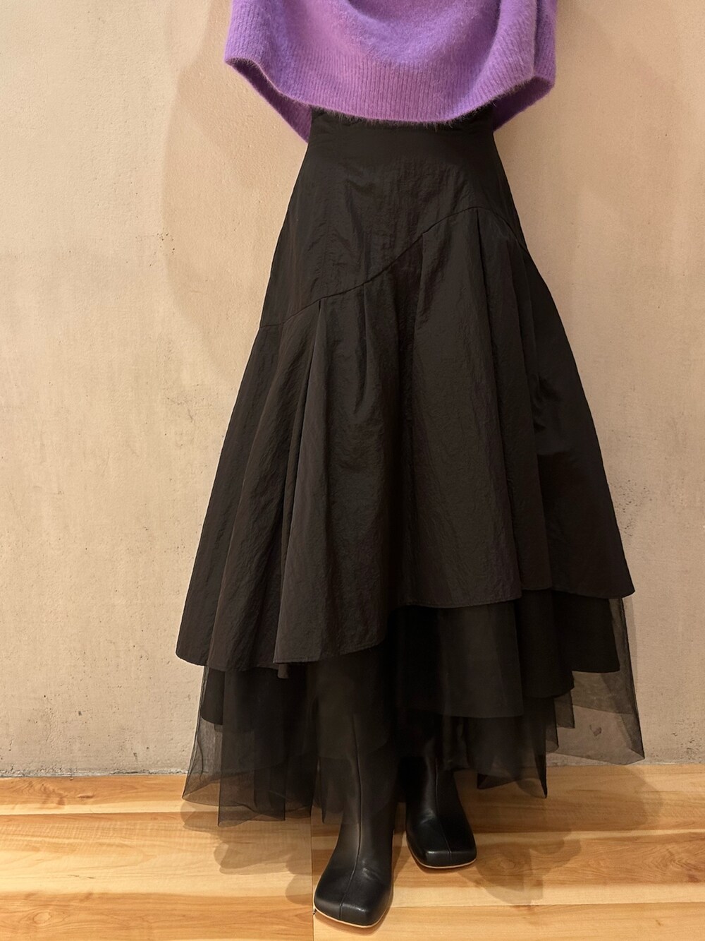 ブラック系のスカート、パープル系のニット/セーター、ブラック系のブーツを着用したレディースの秋コーディネートの10枚目の写真