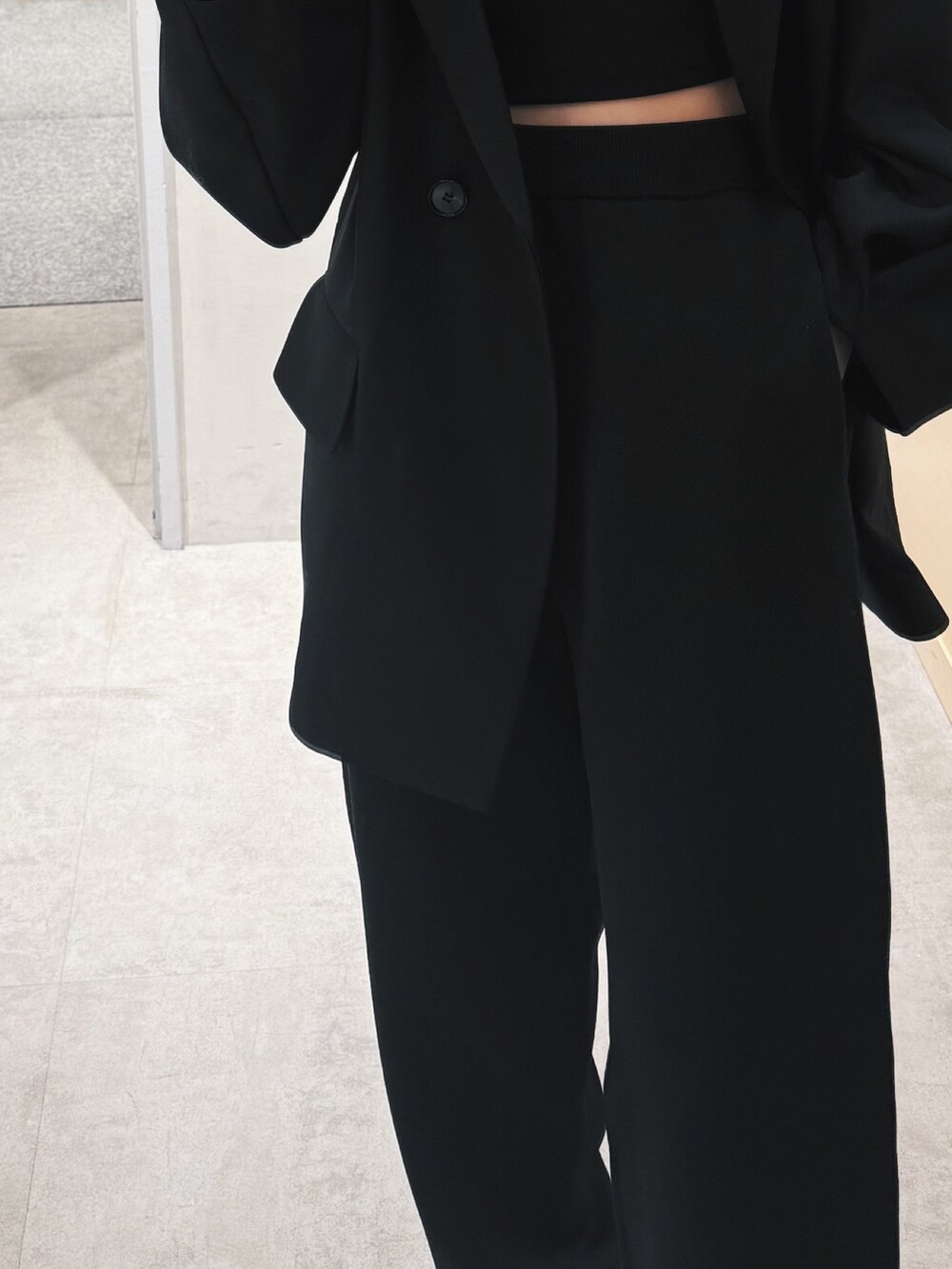 ブラック系のテーラードジャケット、ブラック系のその他パンツ、ブラック系のショルダーバッグを着用したレディースの冬コーディネートの9枚目の写真
