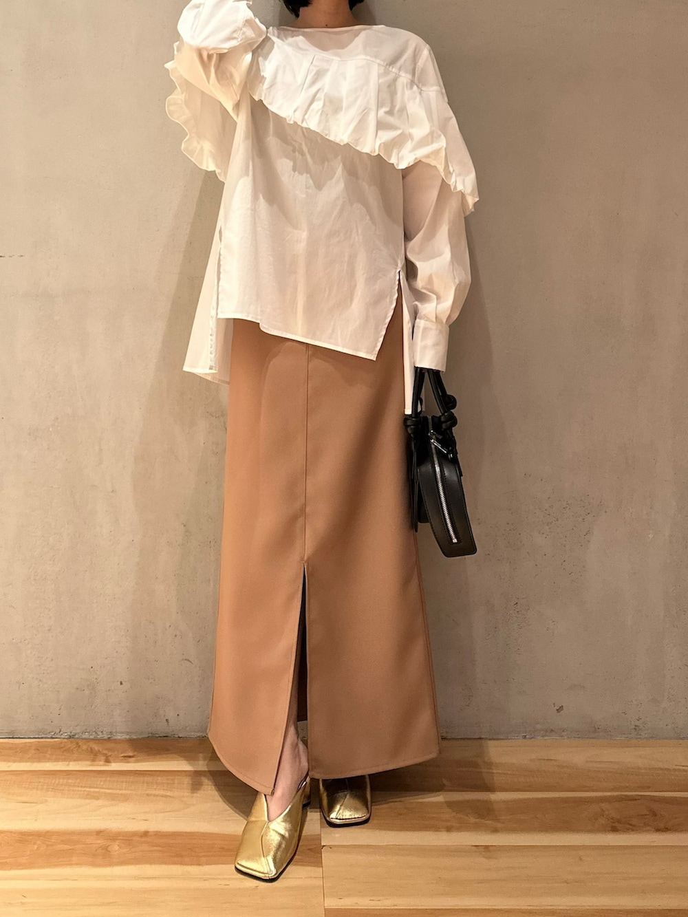 ホワイト系のシャツ/ブラウス、ベージュ系のスカート、ゴールド系のパンプスを着用したレディースの冬コーディネートの4枚目の写真