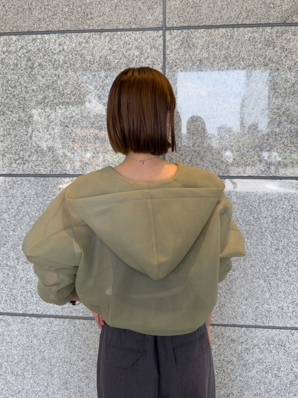 グリーン系のブルゾン、グレー系のその他パンツ、シルバー系のパンプスを着用したレディースの夏コーディネートの7枚目の写真