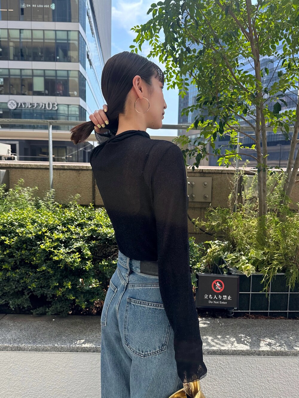 ブルー系のデニムパンツ、ブラック系のパンプス、ブラック系のニット/セーターを着用したレディースの夏コーディネートの7枚目の写真