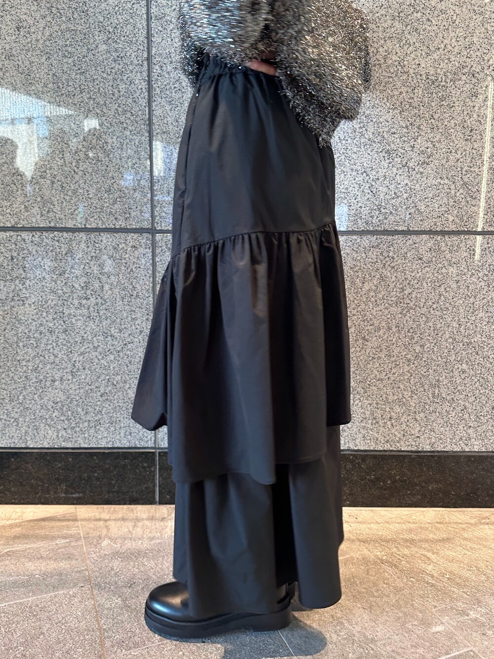 ブラック系のニット/セーター、ブラック系のスカートを着用したレディースの秋コーディネートの7枚目の写真