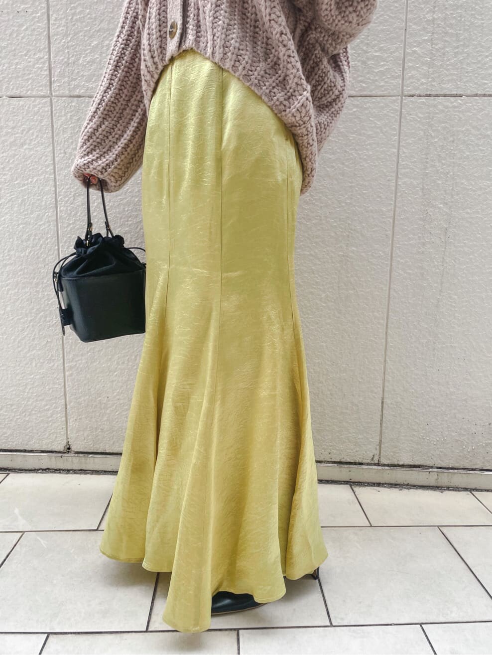 ブラック系のその他シューズ、ベージュ系のカーディガン/ボレロ、イエロー系のスカートを着用したレディースの冬コーディネートの7枚目の写真