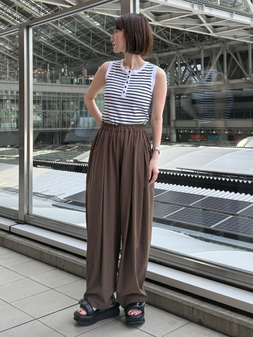 ブラック系のサンダル、ホワイト系のニット/セーター、ブラウン系のその他パンツを着用したレディースの夏コーディネートの2枚目の写真