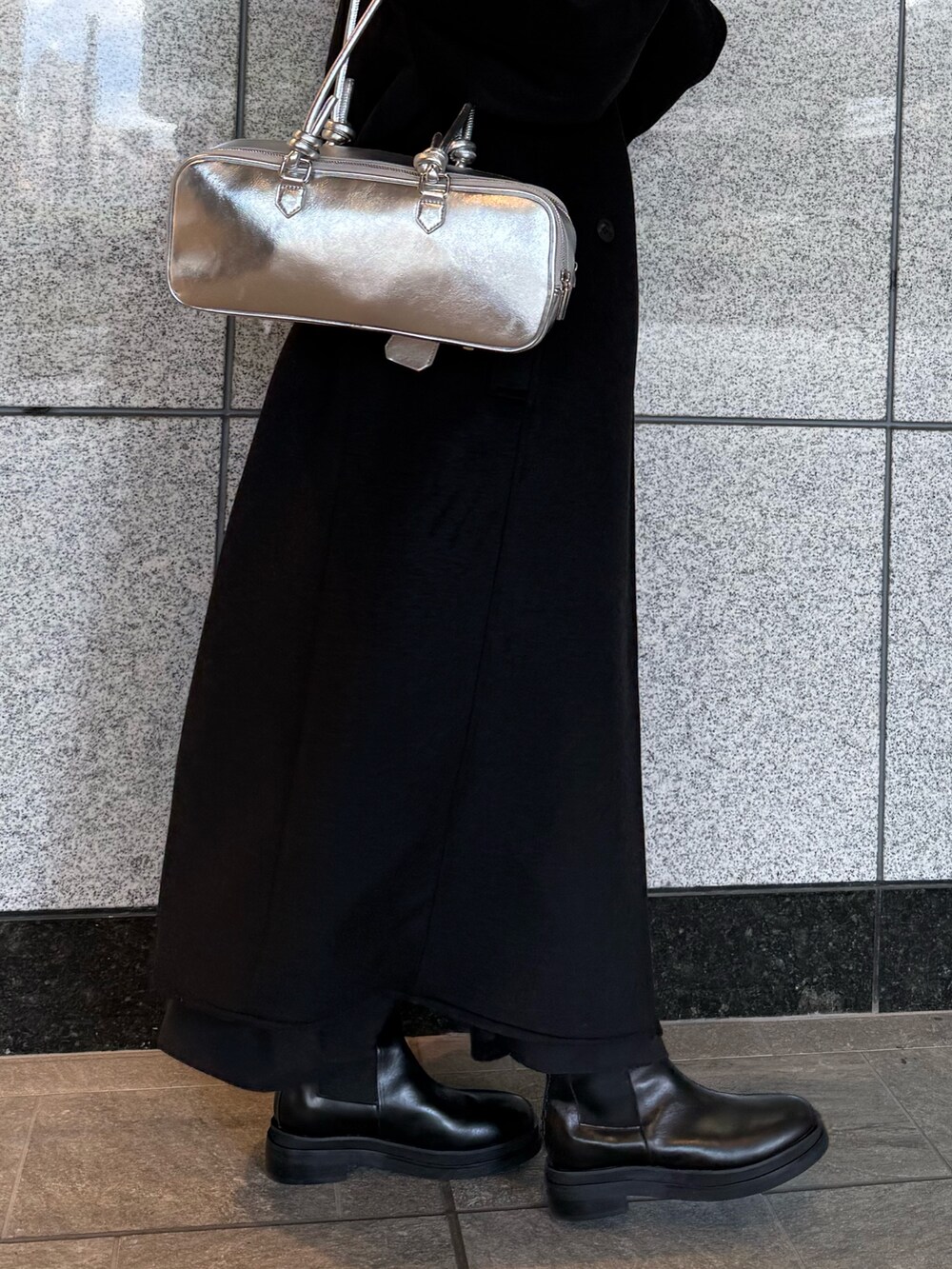 ブラック系のその他アウター、シルバー系のボストンバッグ、ブラック系のブーツを着用したレディースの冬コーディネートの7枚目の写真