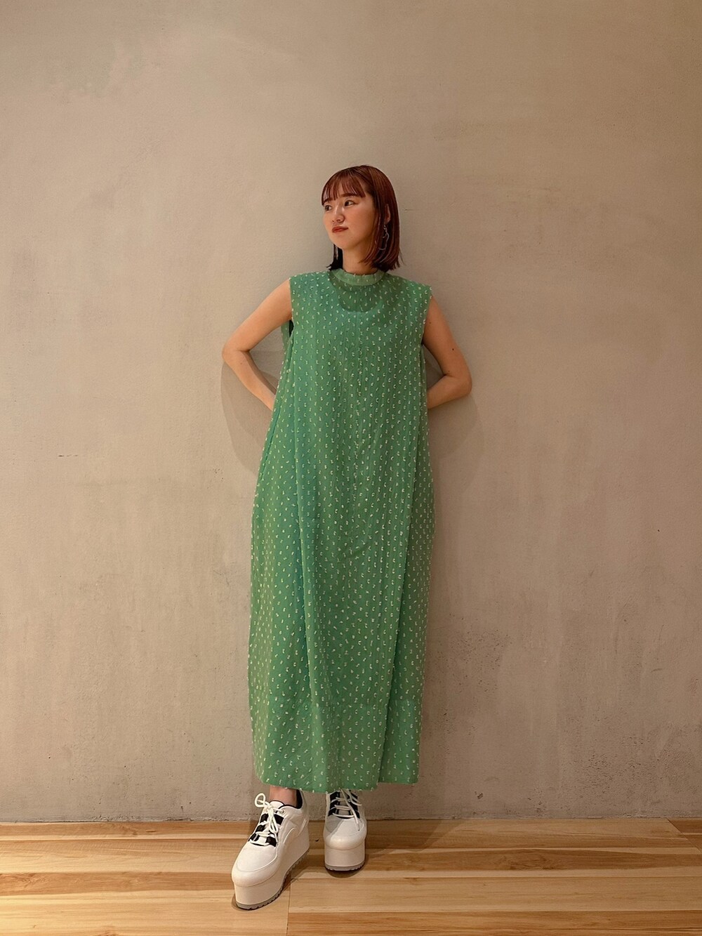 グリーン系のワンピース、ホワイト系のスニーカーを着用したレディースの夏コーディネートの2枚目の写真