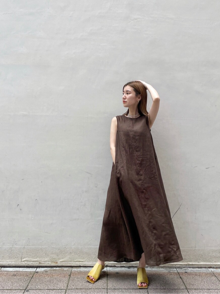 イエロー系のサンダル、ブラウン系のワンピース、ベージュ系のハットを着用したレディースの夏コーディネートの3枚目の写真