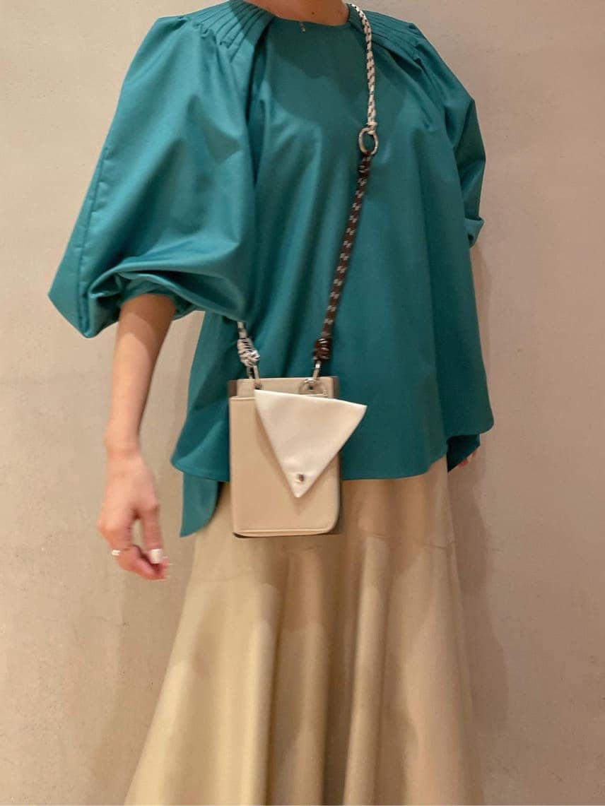 ベージュ系のスカート、ブルー系のスニーカー、グリーン系のシャツ/ブラウスを着用したレディースの秋コーディネートの3枚目の写真