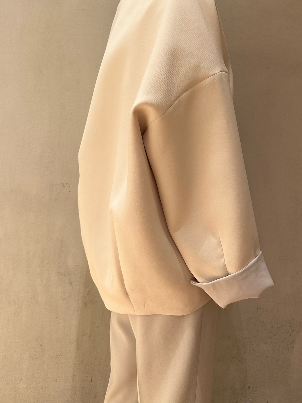 グレー系のその他パンツ、ベージュ系のハンドバッグ、ブラウン系のノーカラーコートを着用したレディースの冬コーディネートの7枚目の写真