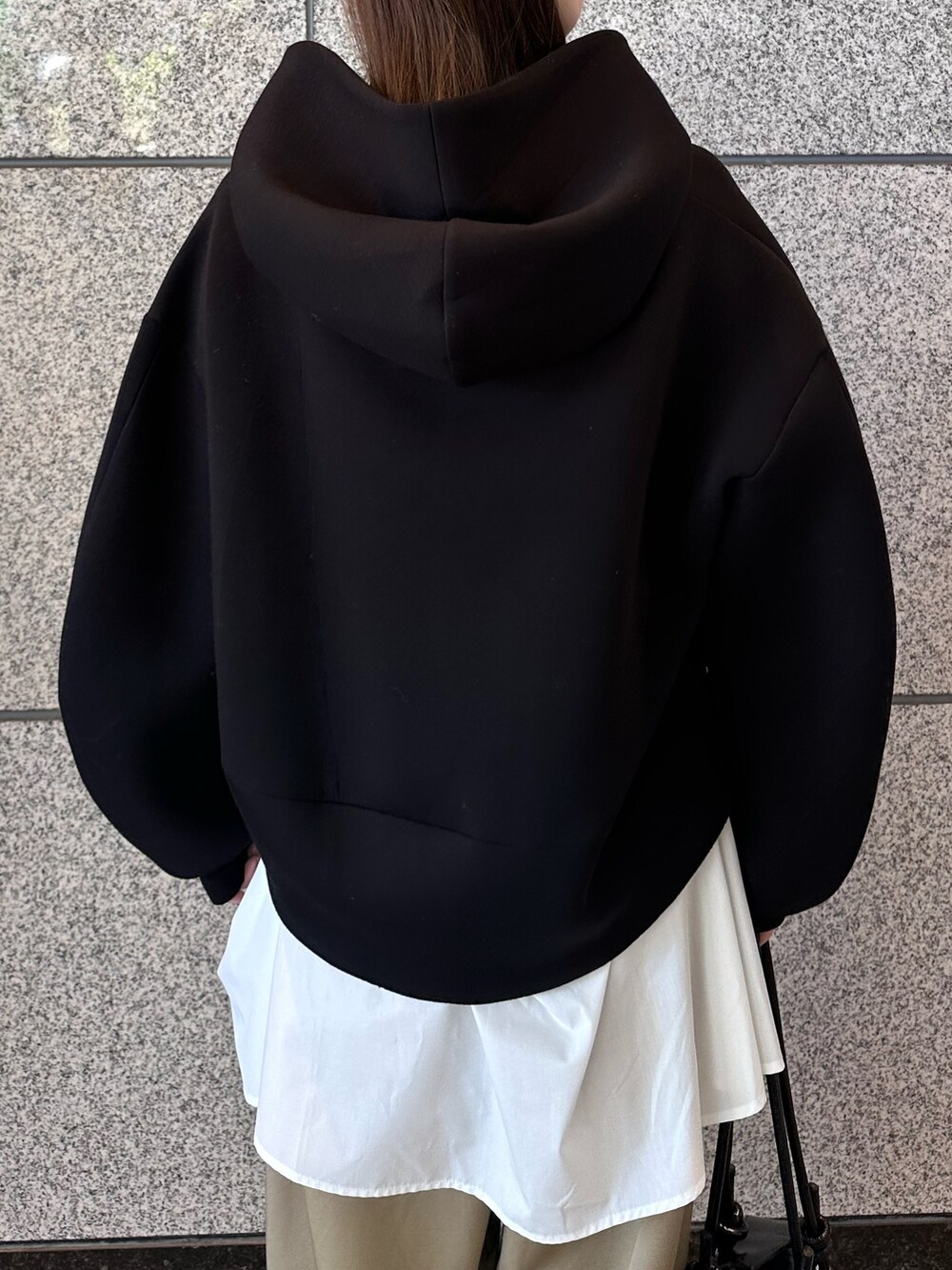 ベージュ系のその他パンツ、ブラック系のボストンバッグ、ブラック系のパーカーを着用したレディースの秋コーディネートの8枚目の写真