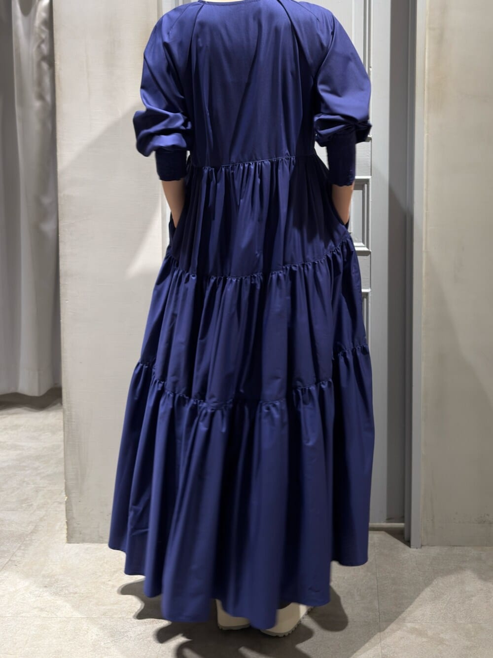 ブルー系のワンピース、グレー系のスニーカーを着用したレディースの秋コーディネートの5枚目の写真