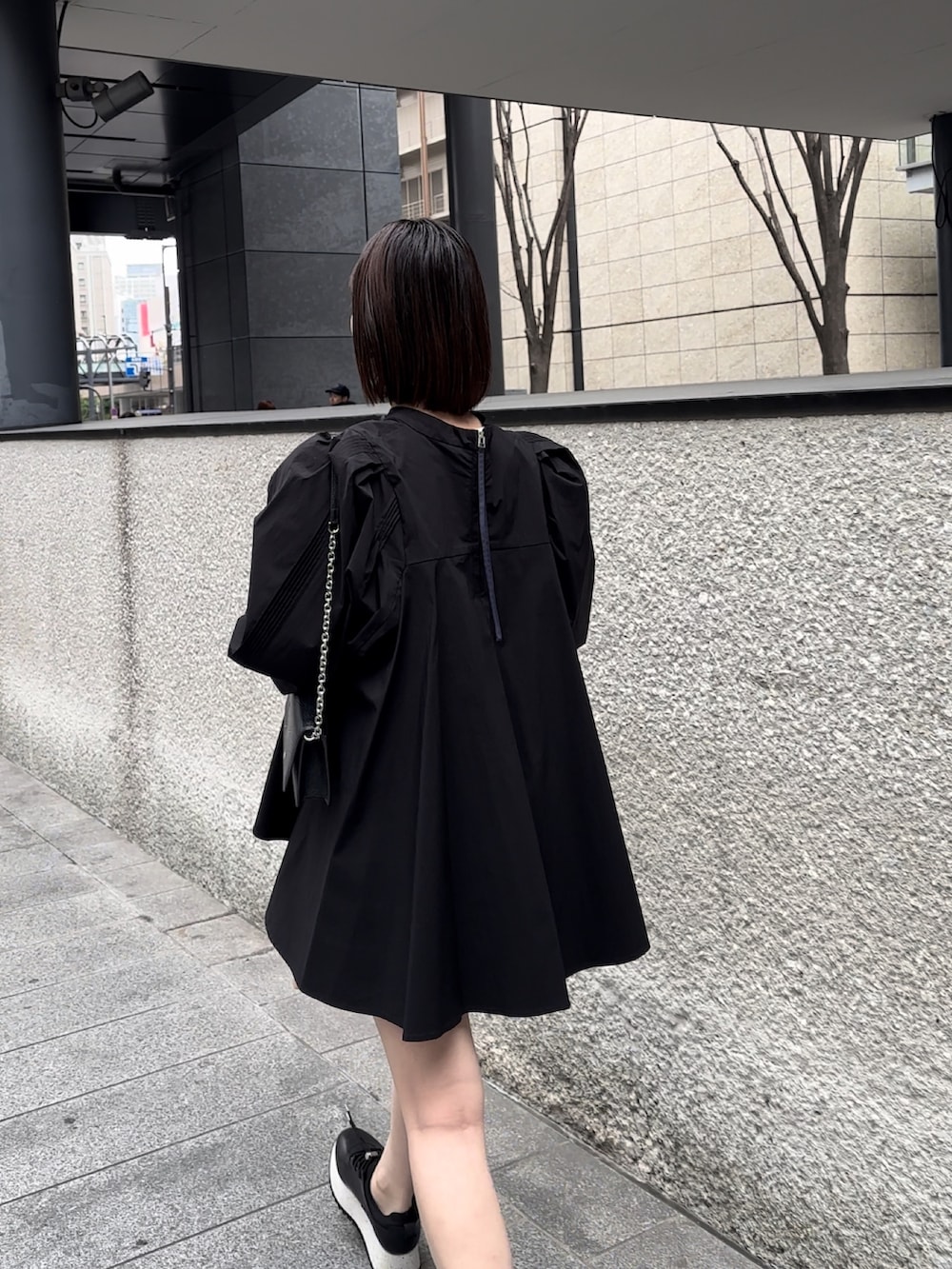 ブラック系のショルダーバッグ、ブラック系のシャツ/ブラウス、ブラック系のスニーカーを着用したレディースの冬コーディネートの3枚目の写真