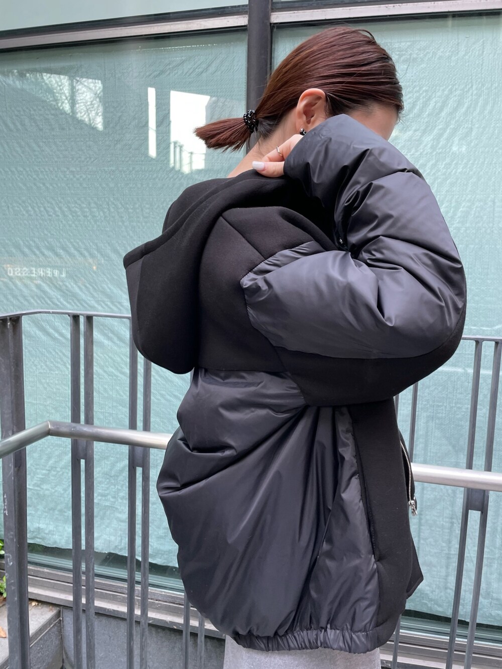 グレー系のワンピース、ブラック系のダウンジャケット/コート、ブラック系の財布を着用したレディースの冬コーディネートの9枚目の写真