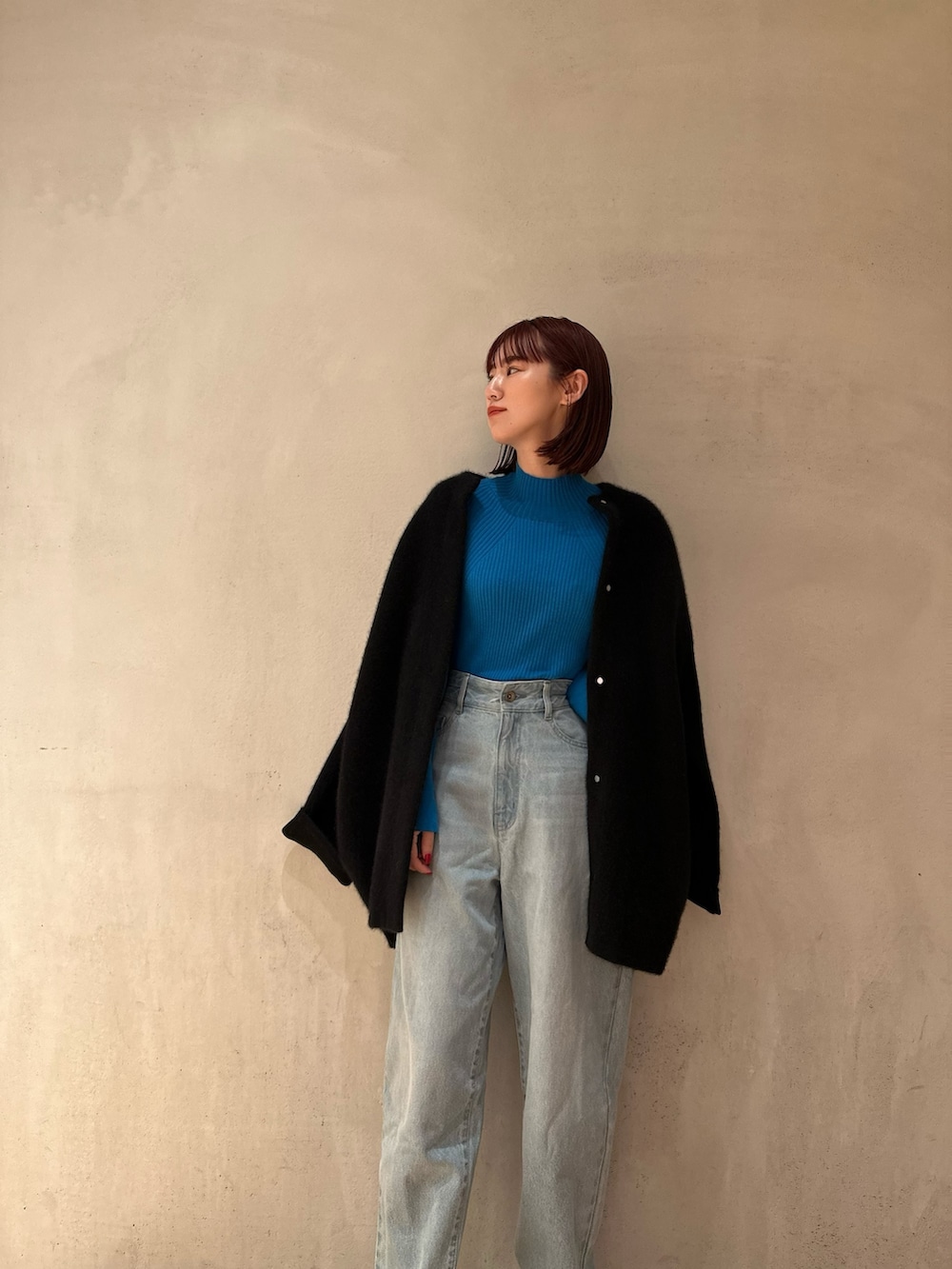 ブラック系のノーカラージャケット、ブルー系のニット/セーター、ブルー系のデニムパンツを着用したレディースの夏コーディネートの3枚目の写真