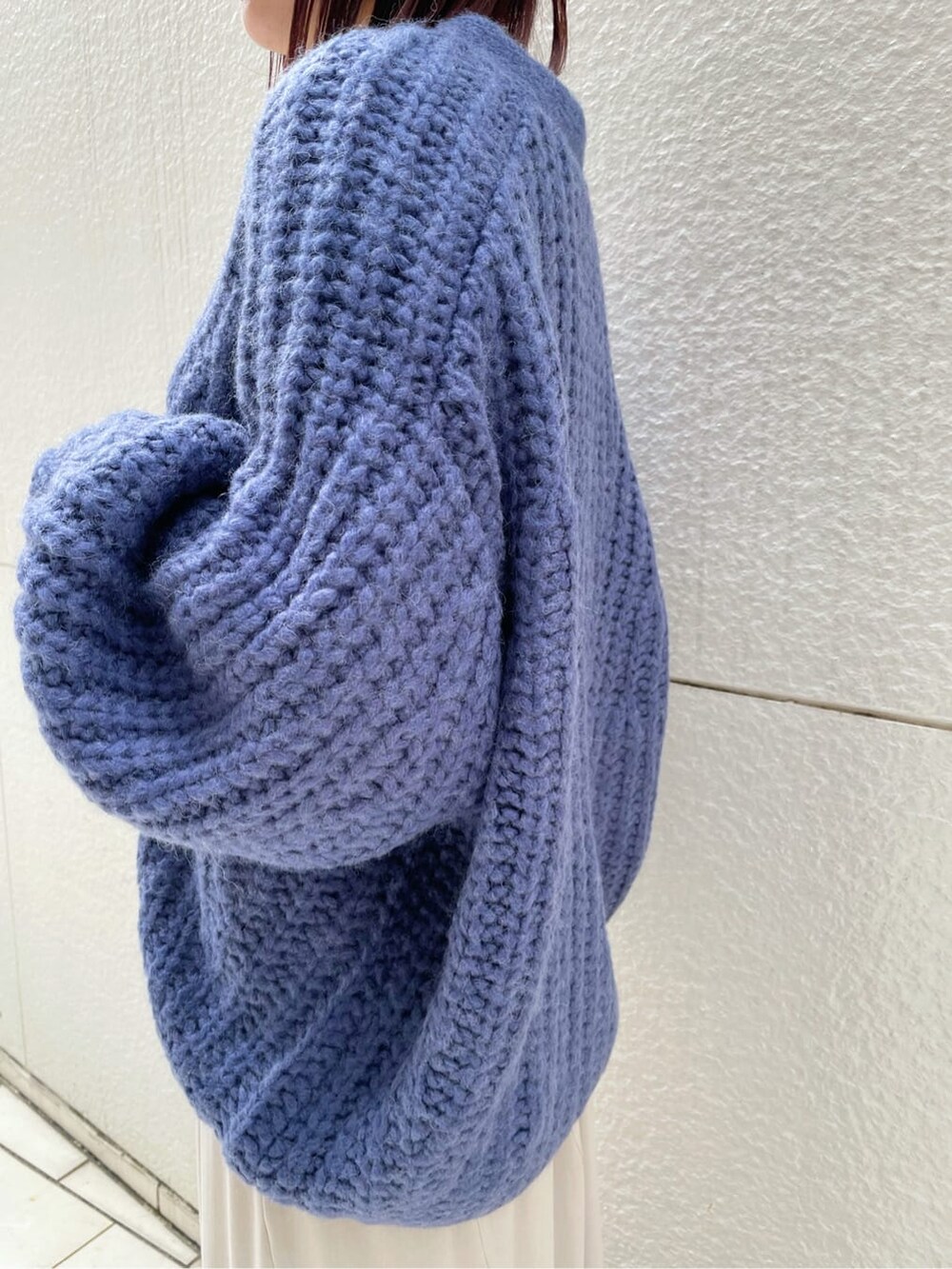 グレー系のニット/セーター、グレー系のスカート、ブラック系のその他シューズを着用したレディースの秋コーディネートの6枚目の写真