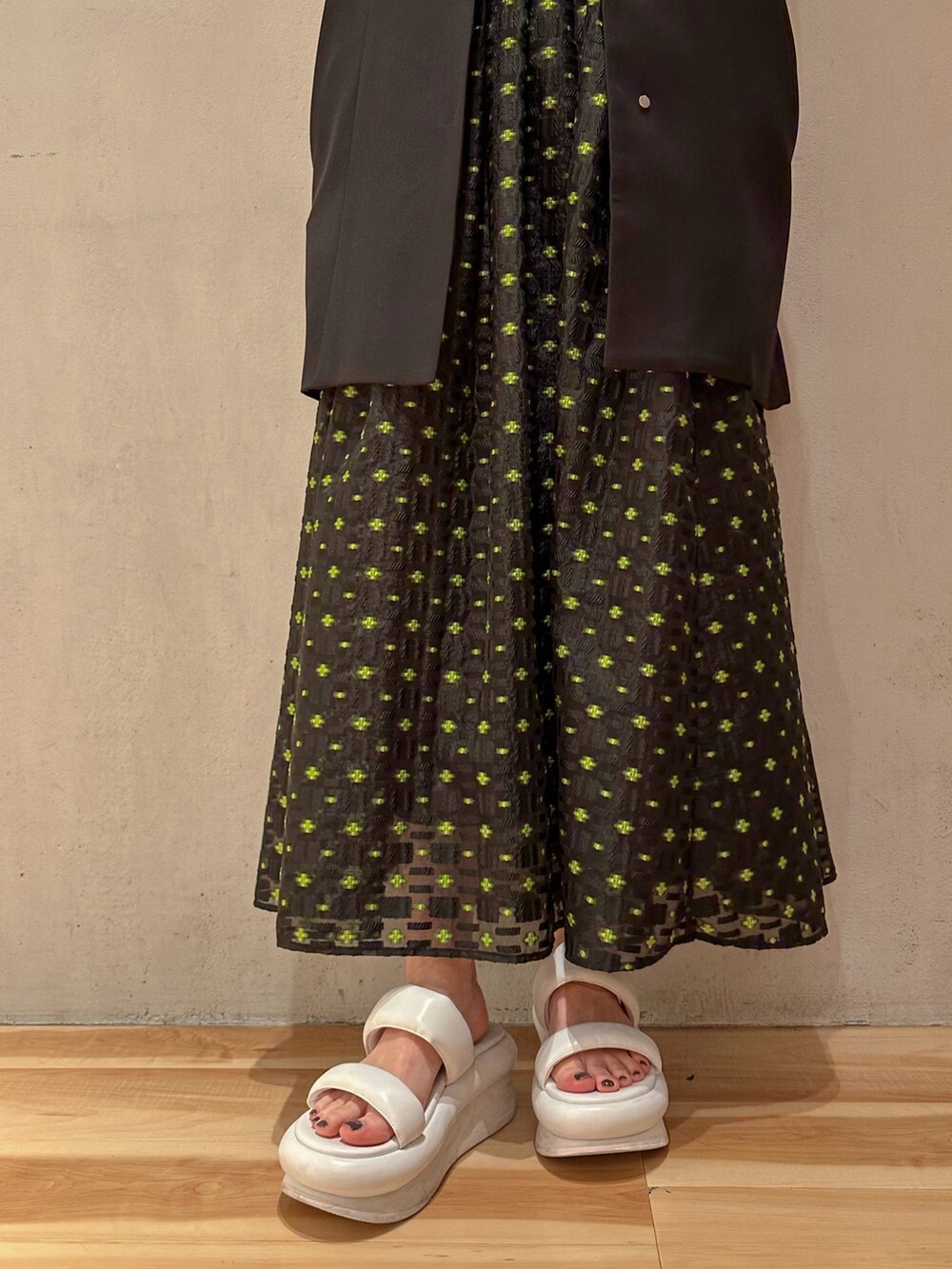 ブラック系のテーラードジャケット、その他のスカート、ホワイト系のサンダルを着用したレディースの冬コーディネートの5枚目の写真