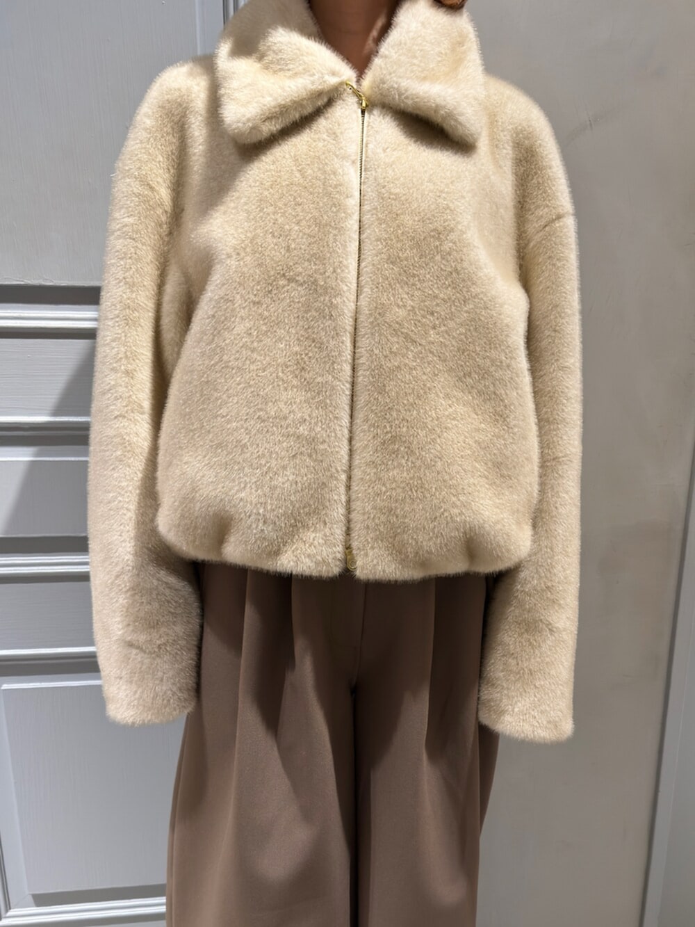 ベージュ系のブルゾン、ブラウン系のその他パンツを着用したレディースの冬コーディネートの6枚目の写真