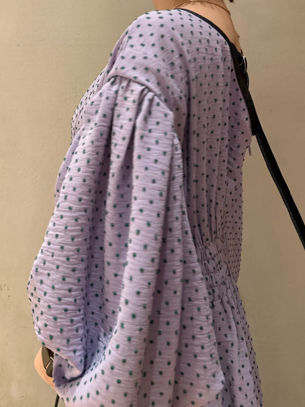 パープル系のワンピース、ベージュ系のテーラードジャケット、ブラック系のサンダルを着用したレディースの冬コーディネートの7枚目の写真