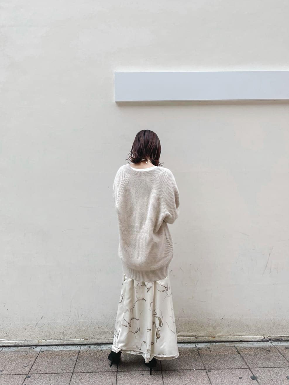 ホワイト系のスカート、ホワイト系のニット/セーター、ホワイト系のTシャツ/カットソーを着用したレディースの秋コーディネートの3枚目の写真