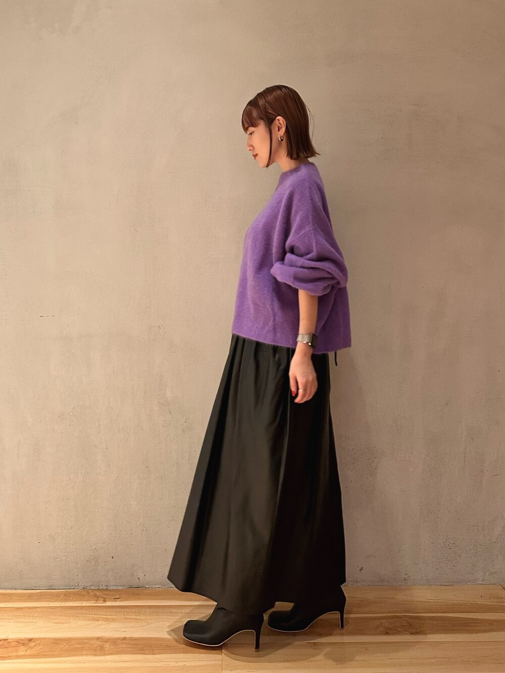 ブラック系のブーツ、ブラック系のジャンパースカート、パープル系のニット/セーターを着用したレディースの秋コーディネートの3枚目の写真