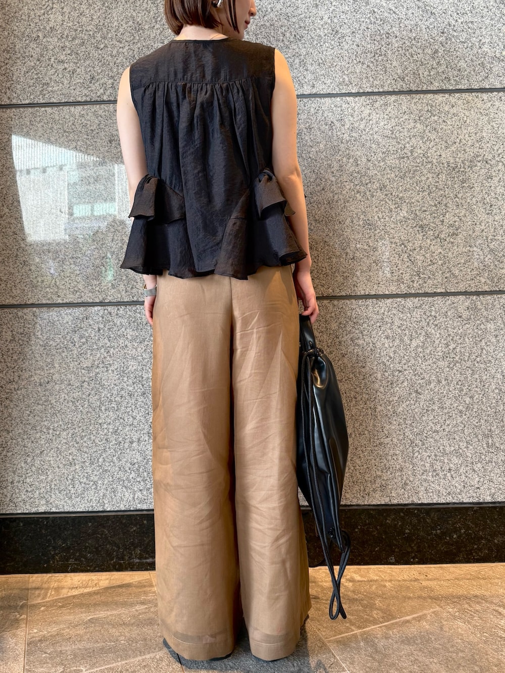 ブラック系のシャツ/ブラウス、ブラウン系のその他パンツ、ブラック系のバックパック/リュックを着用したレディースの春コーディネートの9枚目の写真