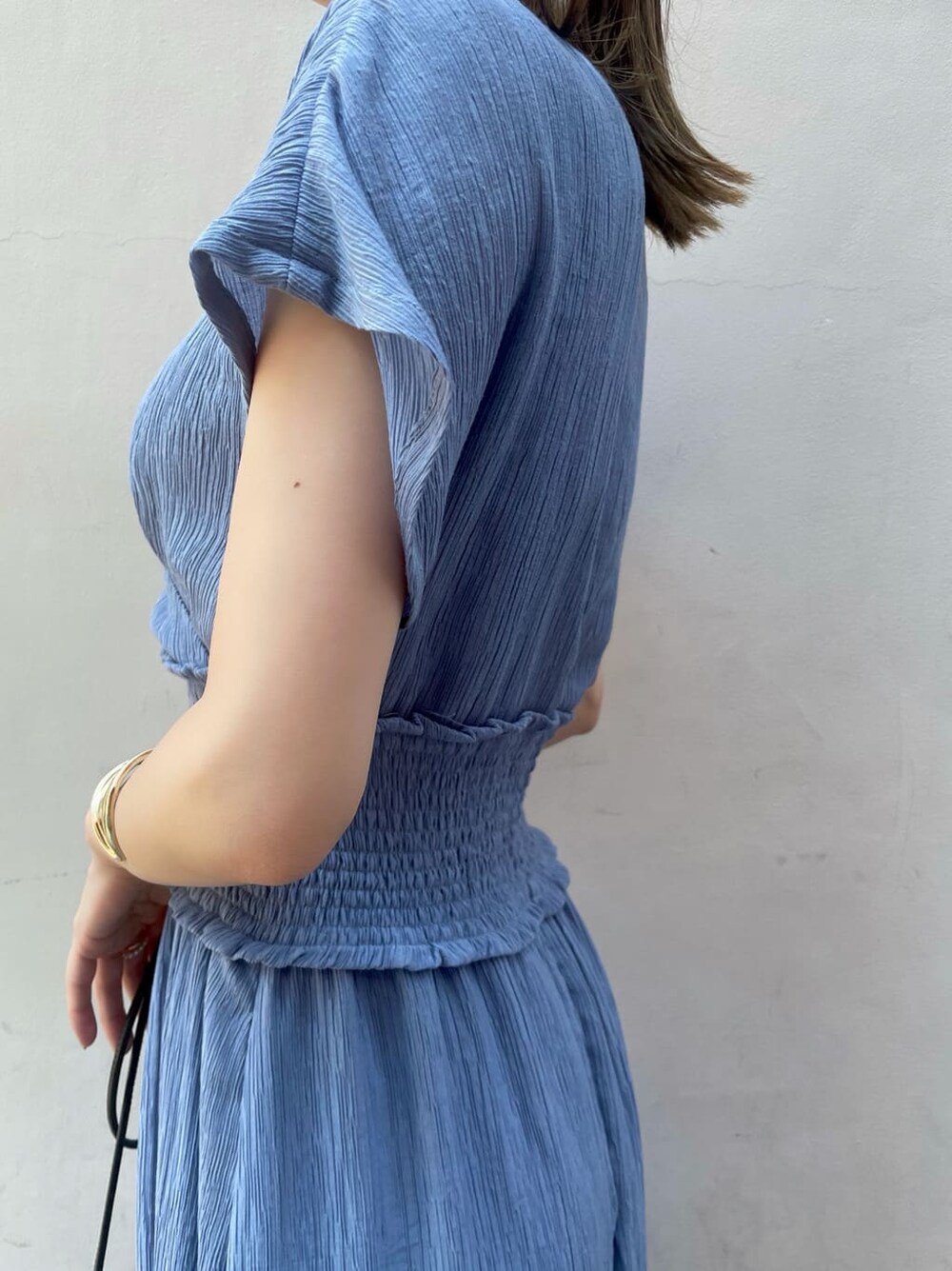 ブラック系のハンドバッグ、ブラック系のサンダル、ブルー系のワンピースを着用したレディースの夏コーディネートの6枚目の写真