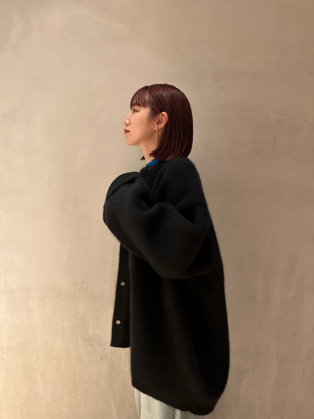 ブラック系のノーカラージャケット、ブルー系のニット/セーター、ブルー系のデニムパンツを着用したレディースの夏コーディネートの4枚目の写真