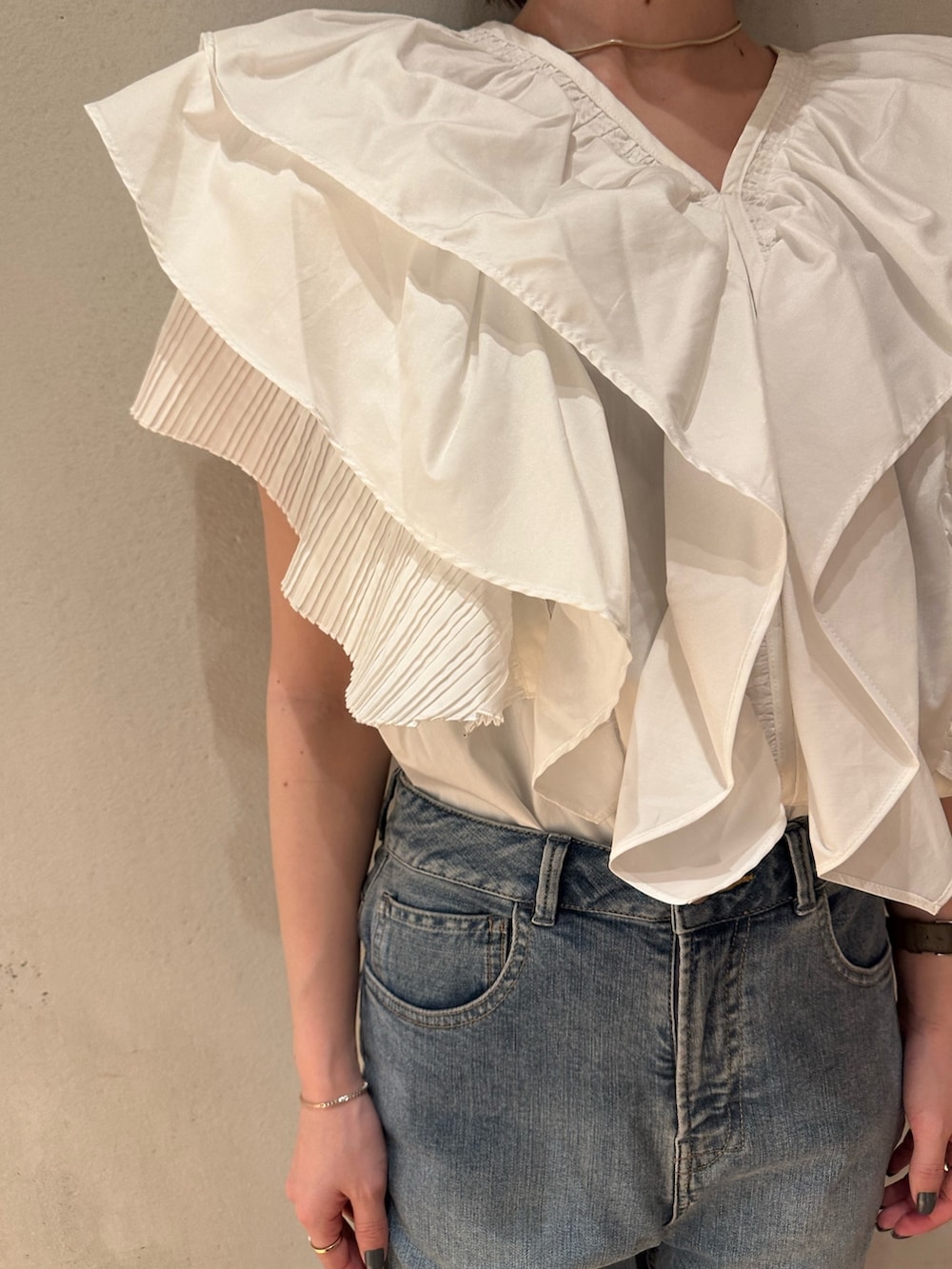 ホワイト系のシャツ/ブラウス、ブラック系のスニーカー、ブルー系のデニムパンツを着用したレディースの春コーディネートの5枚目の写真