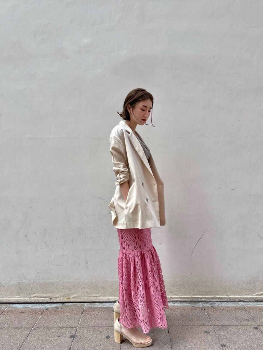 ベージュ系のテーラードジャケット、ピンク系のスカート、その他のパンプスを着用したレディースの春コーディネートの3枚目の写真