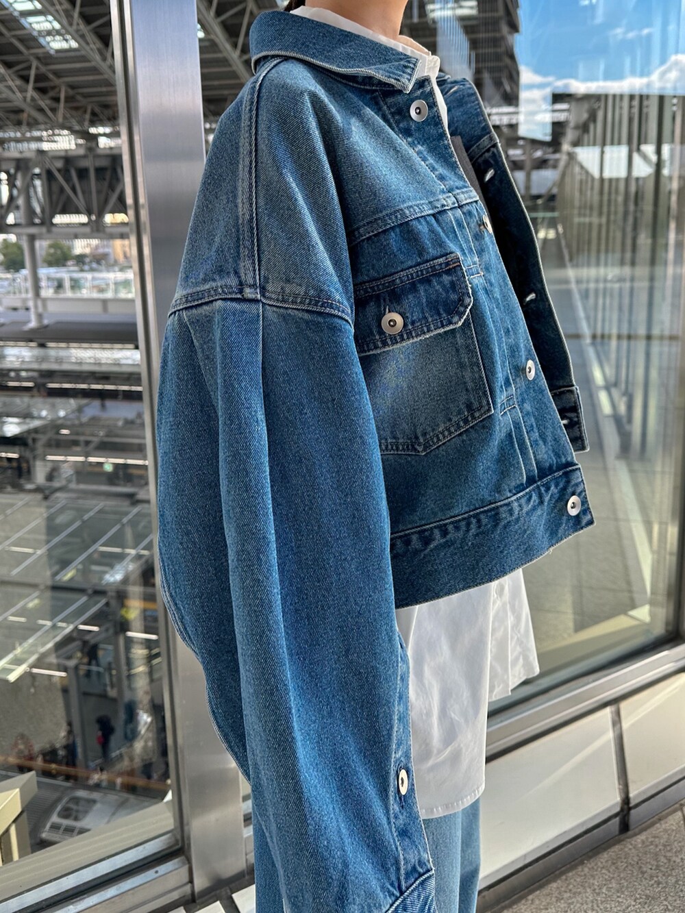 ブルー系のデニムジャケット、ブルー系のデニムパンツ、シルバー系のパンプスを着用したレディースの冬コーディネートの7枚目の写真