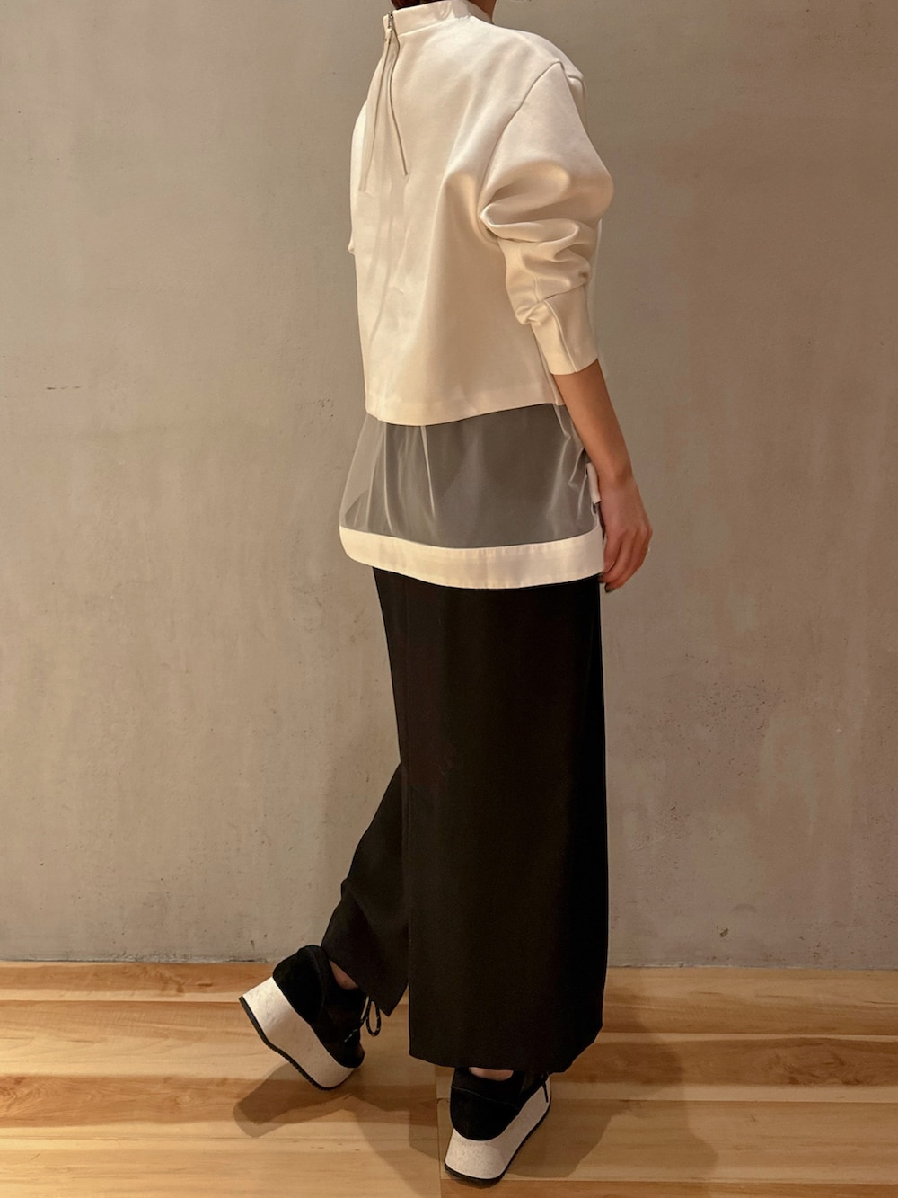 ホワイト系のTシャツ/カットソー、ブラック系のスカート、ブラック系のスニーカーを着用したレディースの冬コーディネートの5枚目の写真