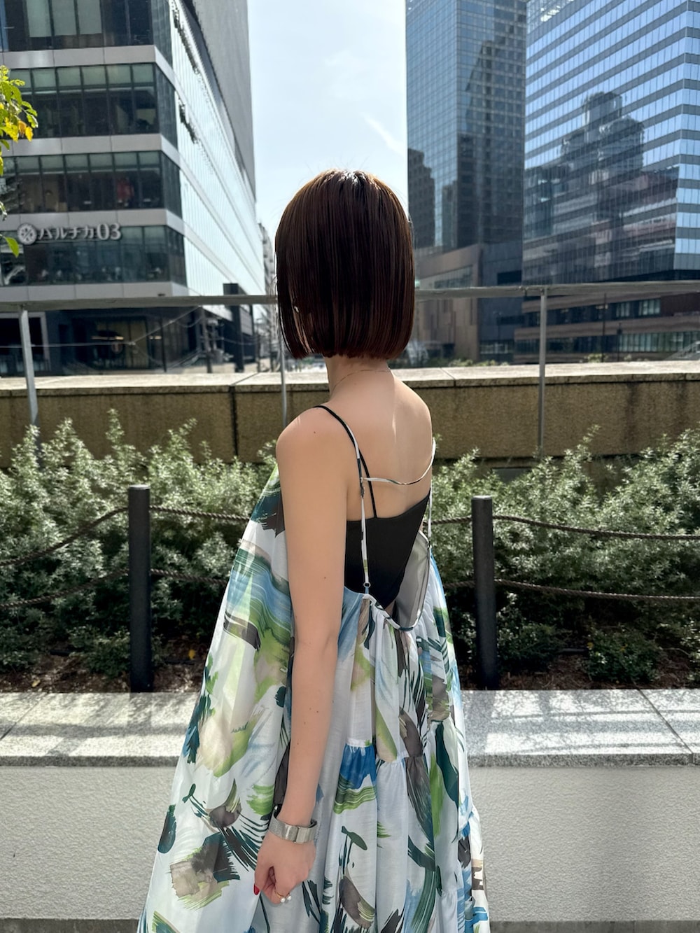 グリーン系のワンピース、シルバー系のトートバッグ、シルバー系のサンダルを着用したレディースの春コーディネートの6枚目の写真