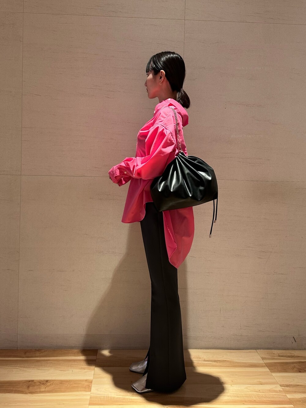 ピンク系のシャツ/ブラウス、シルバー系のパンプス、ブラック系のショルダーバッグを着用したレディースの春コーディネートの3枚目の写真