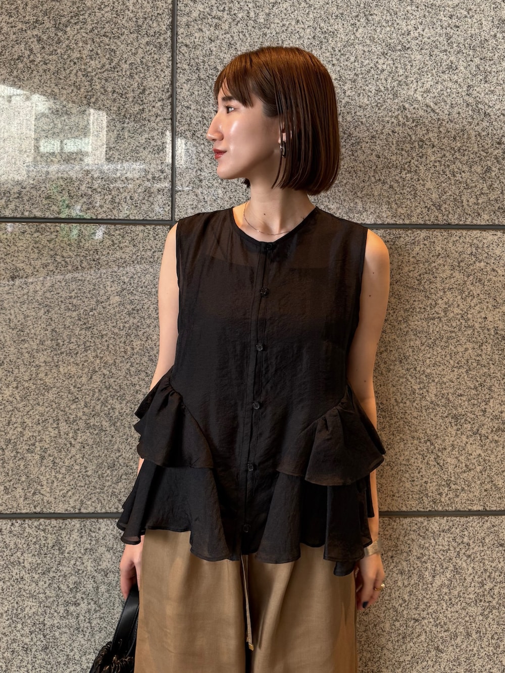 ブラック系のシャツ/ブラウス、ブラウン系のその他パンツ、ブラック系のバックパック/リュックを着用したレディースの春コーディネートの4枚目の写真