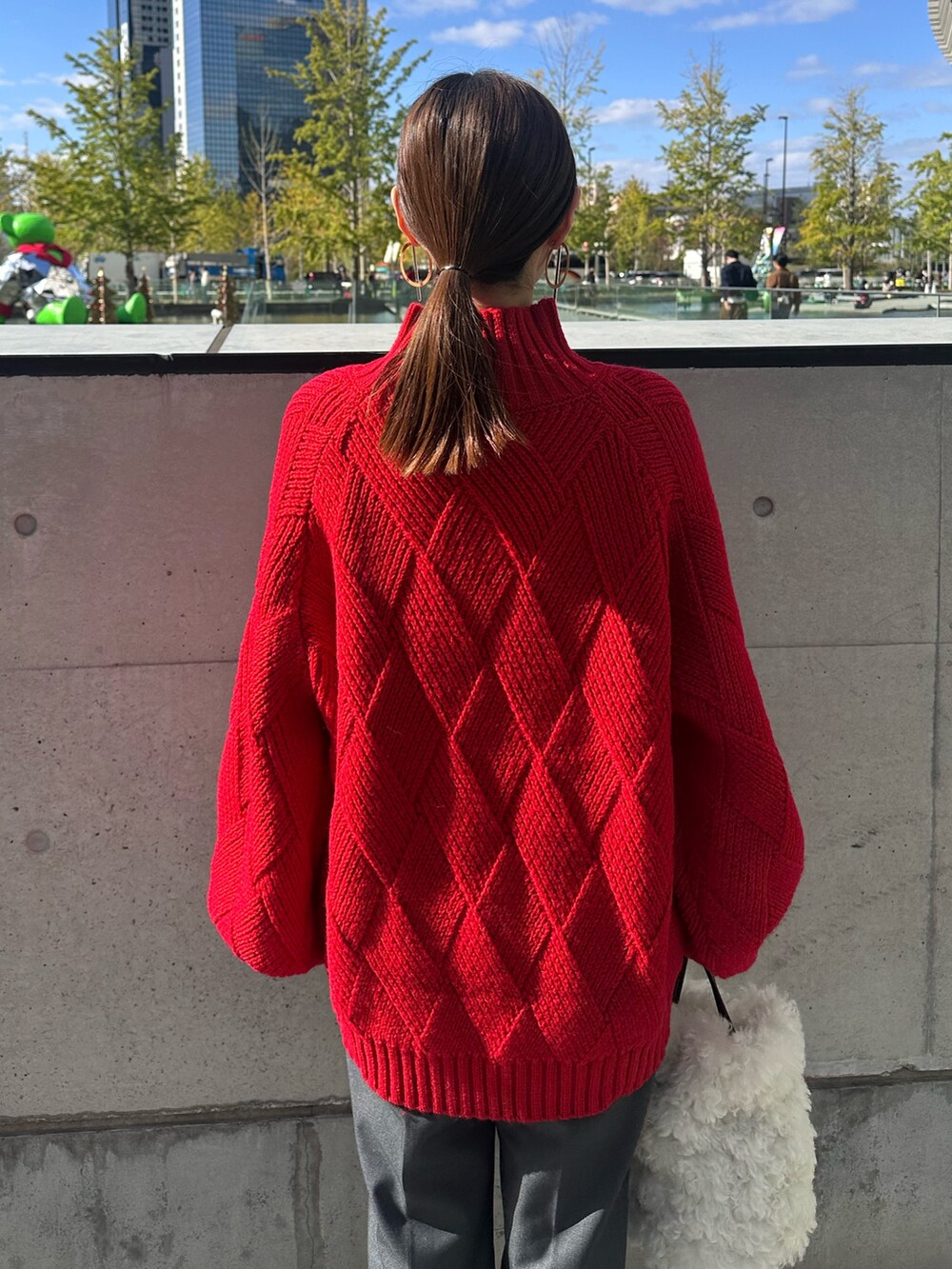 ブラック系のその他アウター、レッド系のニット/セーター、グレー系のその他パンツを着用したレディースの冬コーディネートの8枚目の写真