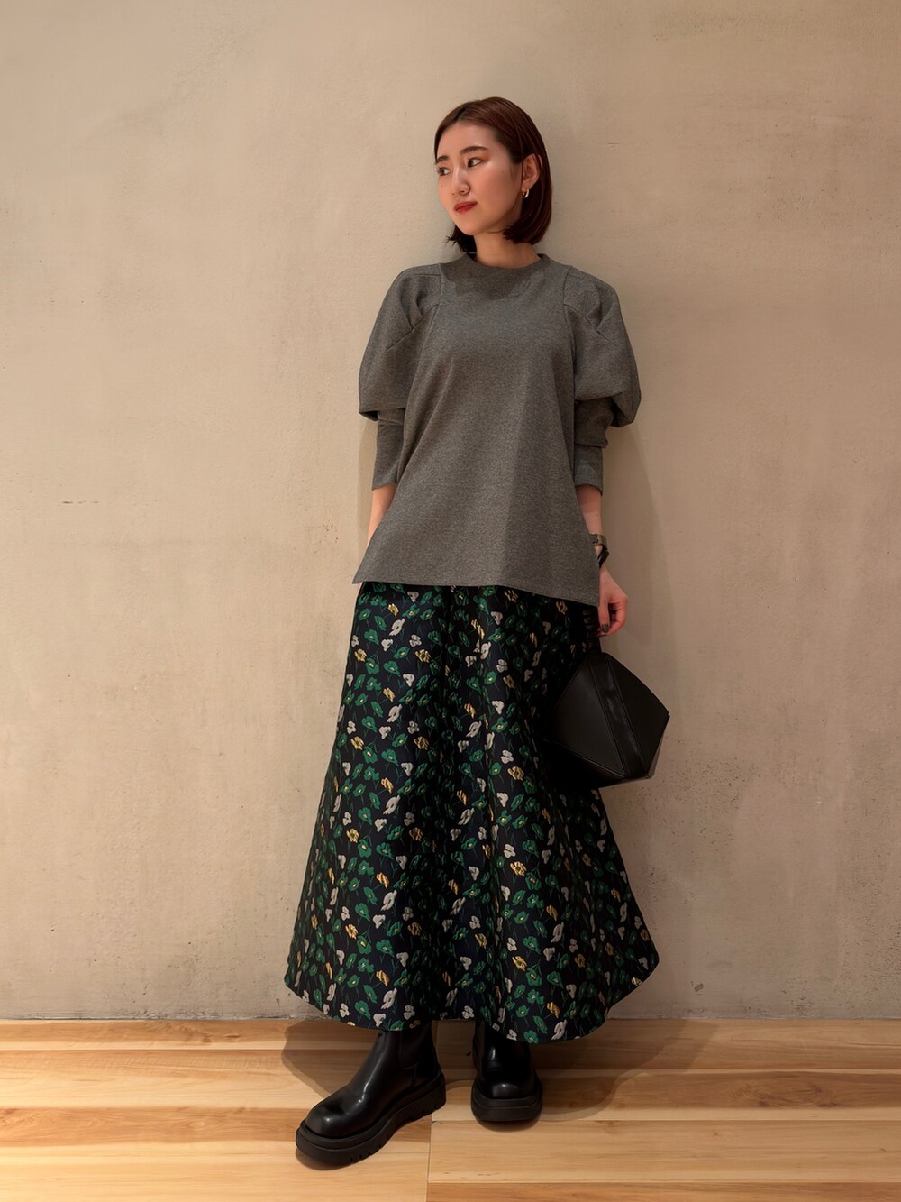 グレー系のTシャツ/カットソー、ブラック系のハンドバッグ、ブルー系のスカートを着用したレディースの春コーディネートの2枚目の写真