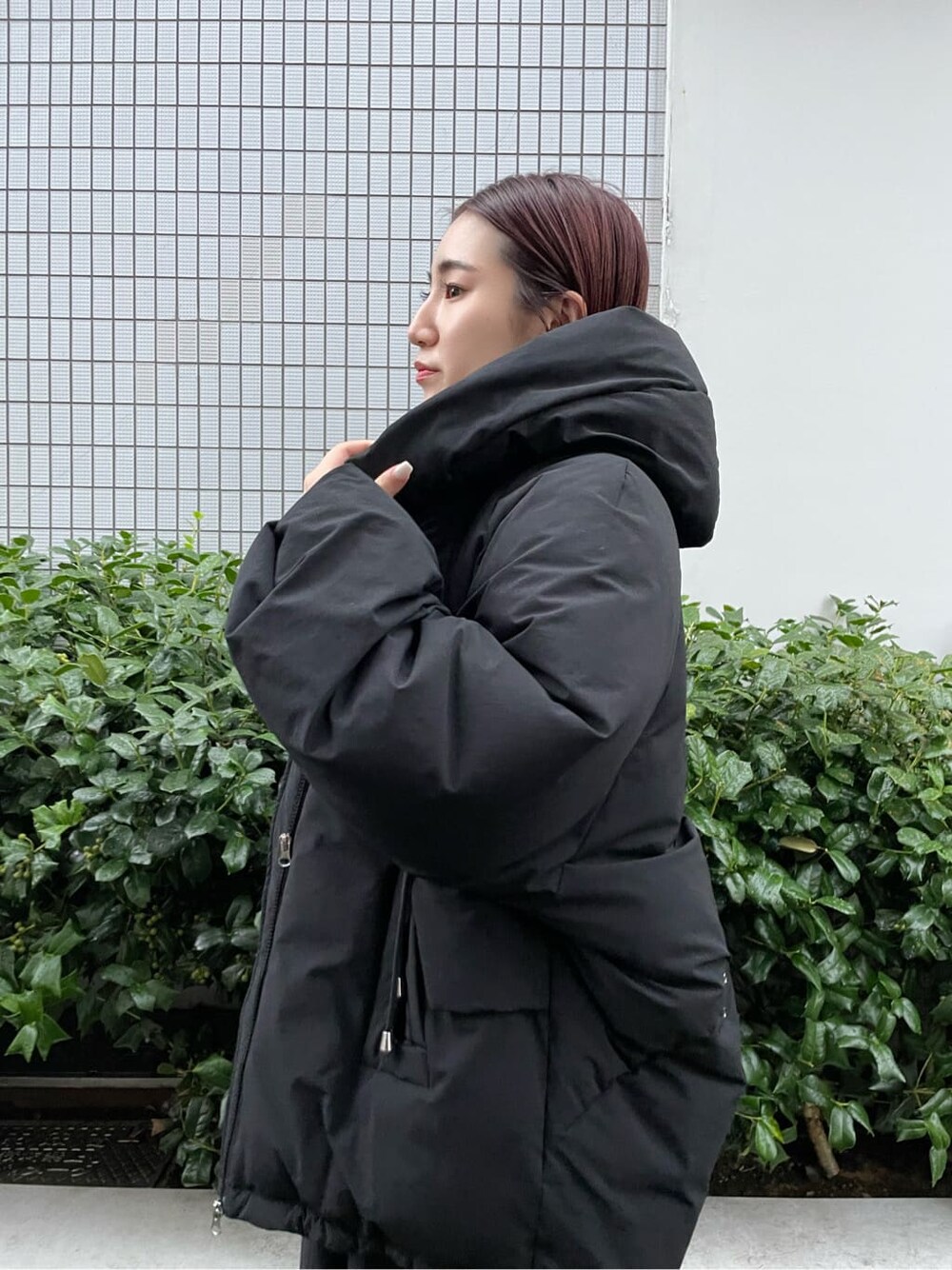 ブラック系のダウンジャケット/コート、ブラウン系のブーツ、ホワイト系のワンピースを着用したレディースの秋コーディネートの8枚目の写真