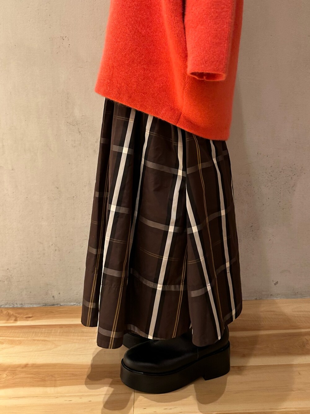 ピンク系のノーカラージャケット、ブラウン系のスカート、ブラック系のブーツを着用したレディースの夏コーディネートの6枚目の写真