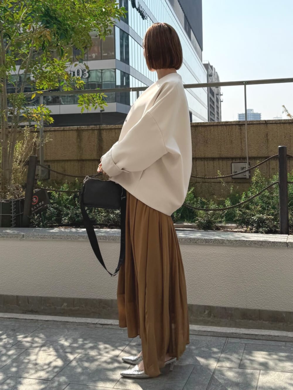 シルバー系のサンダル、ブラウン系のワンピース、ベージュ系のその他アウターを着用したレディースの春コーディネートの2枚目の写真