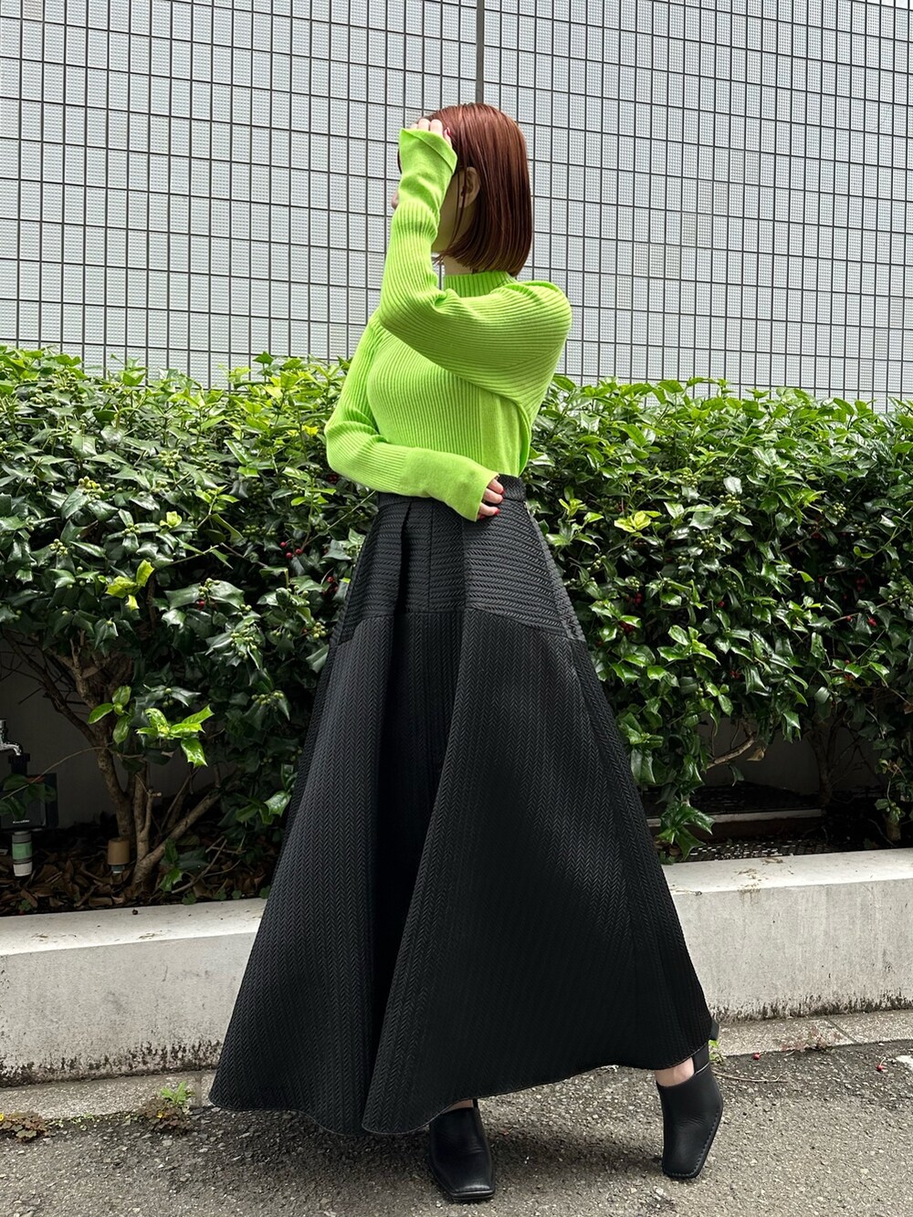 ブラック系のノーカラージャケット、ブラック系のスカート、ブラック系のパンプスを着用したレディースの夏コーディネートの8枚目の写真