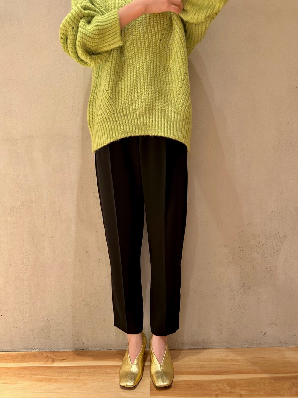 イエロー系のカーディガン/ボレロ、ブラック系のその他パンツ、グリーン系のニット/セーターを着用したレディースの冬コーディネートの8枚目の写真