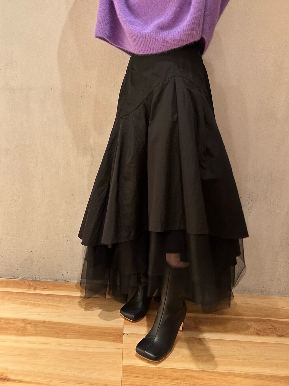 ブラック系のスカート、パープル系のニット/セーター、ブラック系のブーツを着用したレディースの秋コーディネートの8枚目の写真